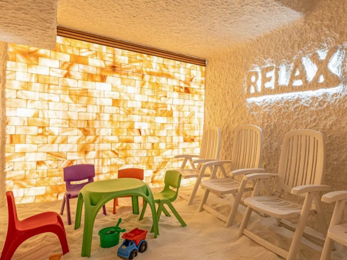 A salt room with loungers and a seascape in an illuminated niche