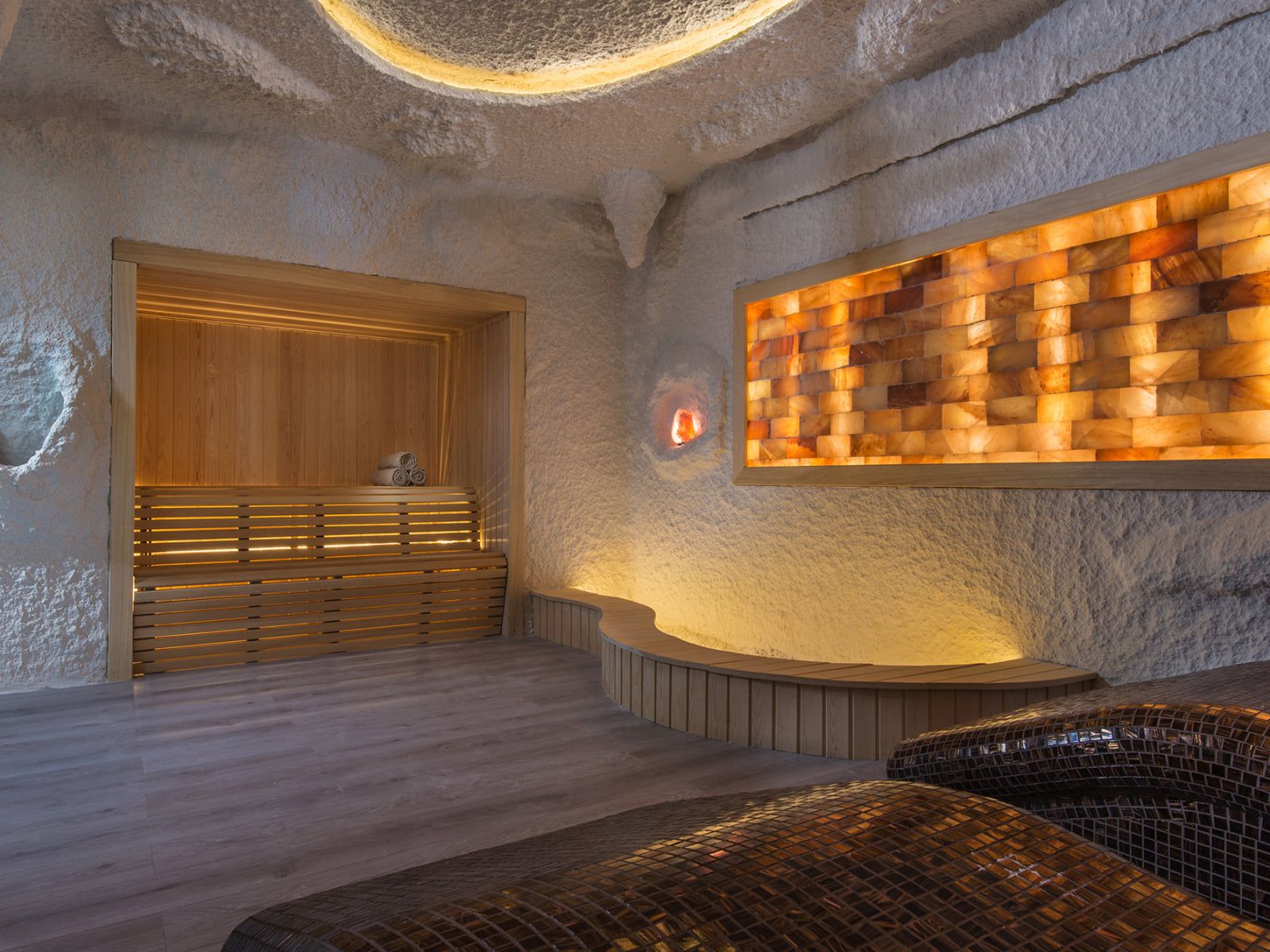 A spa zone with a salt-brick wall, lounge beds and a sauna